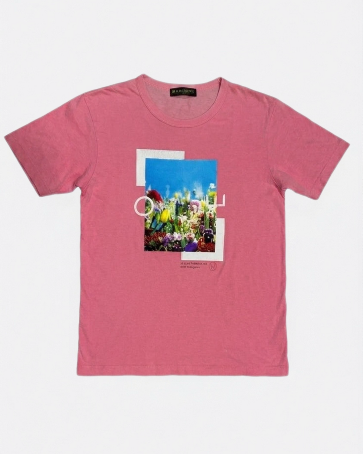 Pink short-sleeve t-shirt with a rectangular floral artwork photo print and white line graphics on the front chest laid flat, front view