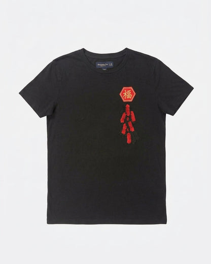 Black Abercrombie & Fitch short-sleeve t-shirt with a red hexagonal Fu patch above red flip-sequin firecrackers on the left chest laid flat, front view