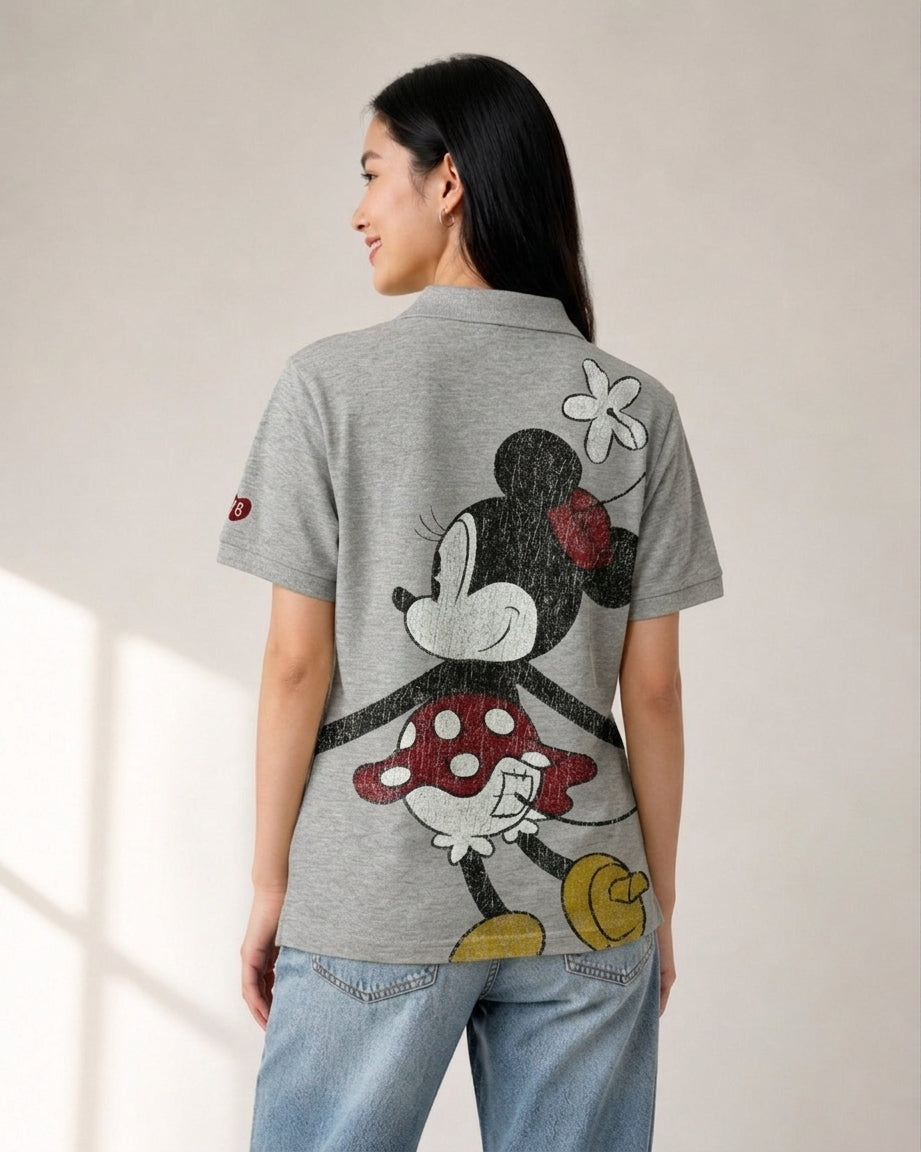 Woman wearing a heather grey Disney polo shirt featuring a large vintage Minnie Mouse back graphic print