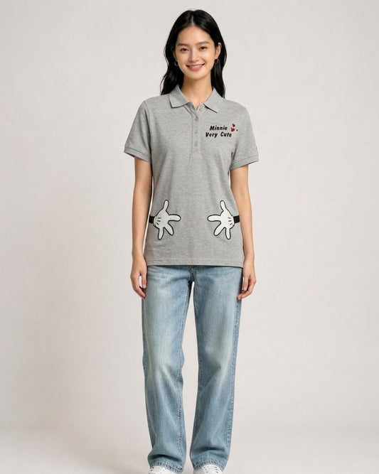 Woman wearing a heather grey Disney polo shirt featuring Minnie Very Cute embroidery and cartoon hand prints