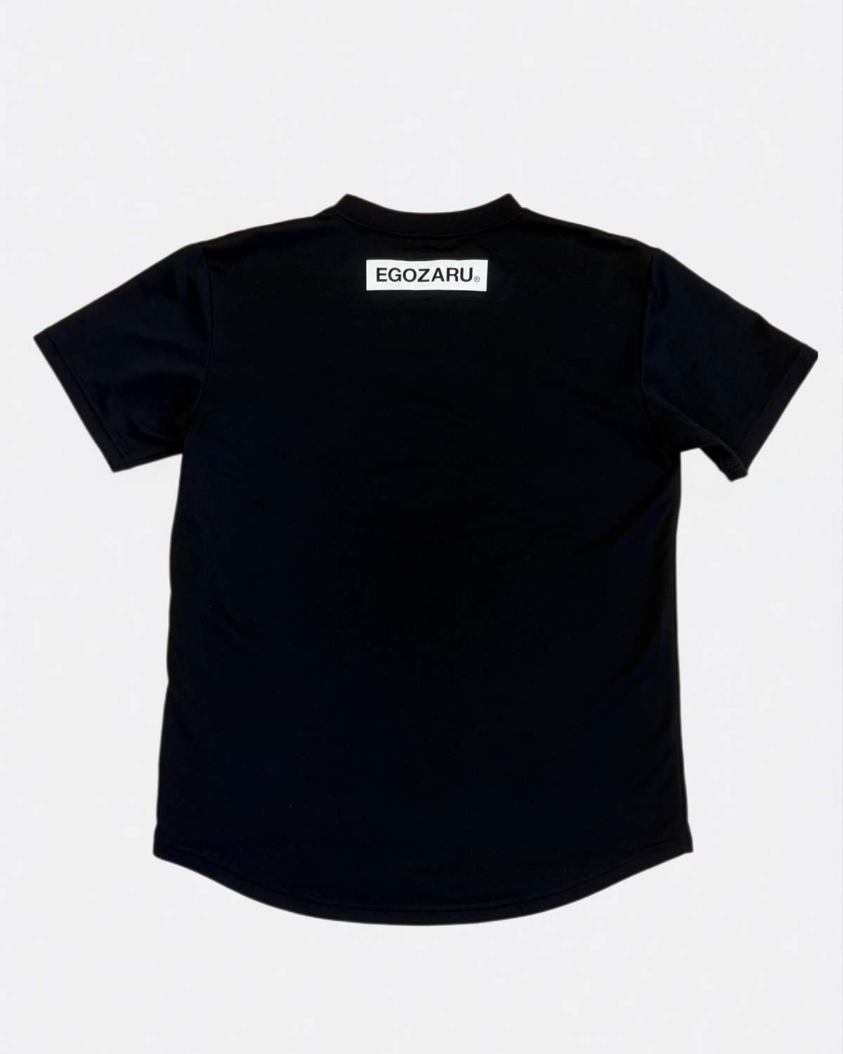Black Egozaru polyester performance basketball t-shirt with white back collar logo print laid flat, back view