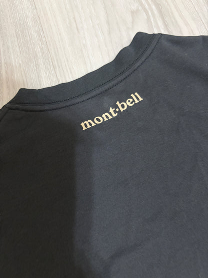 Close-up detail of the cream Montbell logo printed on the upper back neck of a black t-shirt