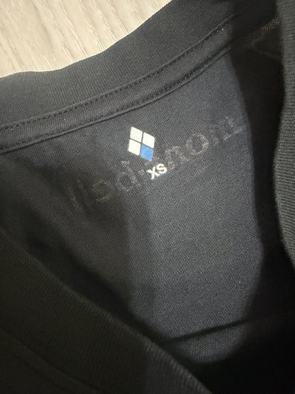 Close-up detail of the printed Montbell inner neck label with four-diamond logo and size XS printed on a black t-shirt