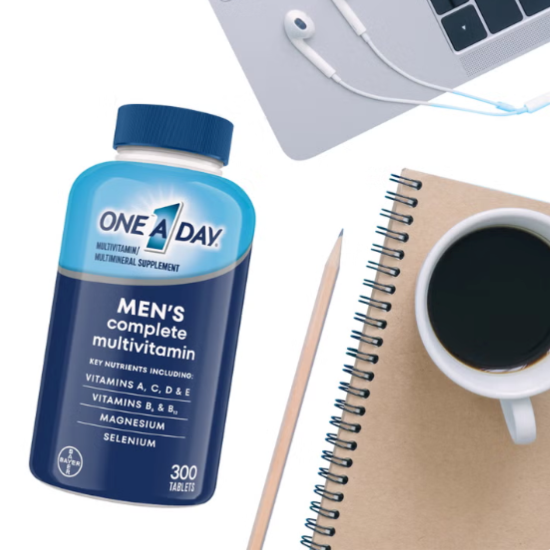 One A Day Men's Complete Multivitamin bottle on a desk alongside a coffee cup, notebook, pencil, and laptop.