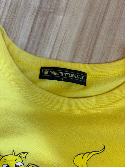 Close-up view of the inner neck collar on a yellow t-shirt displaying a black woven brand label reading 24HOUR TELEVISION in white block text above size L